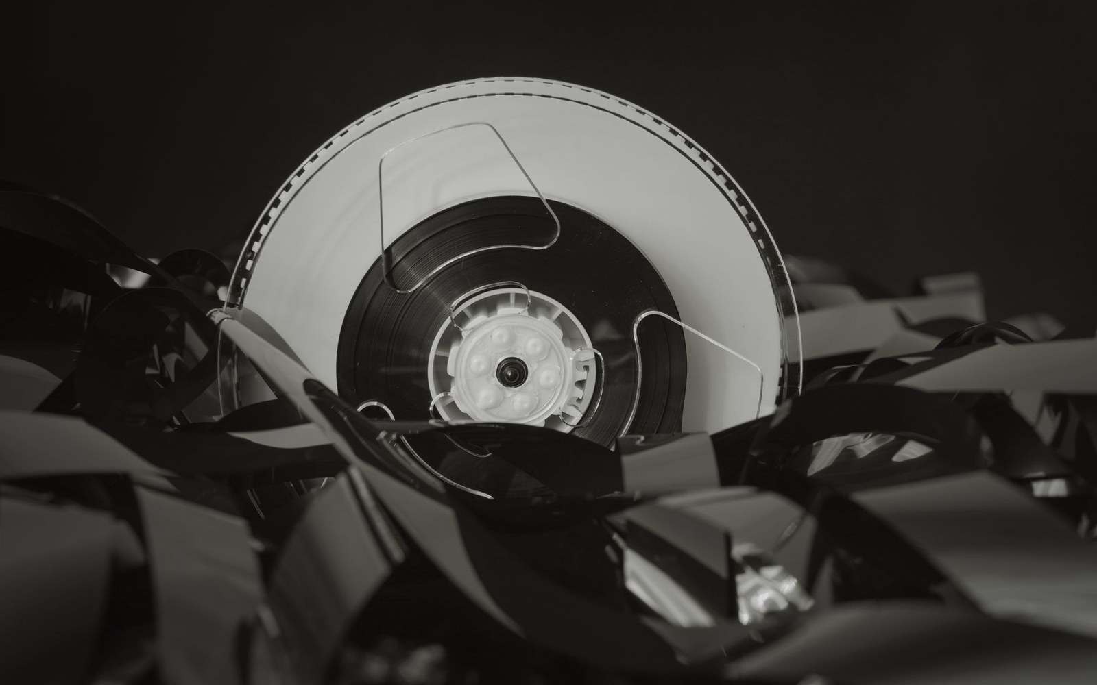 A film reel surrounded by tangled strips of unspooled celluloid tape